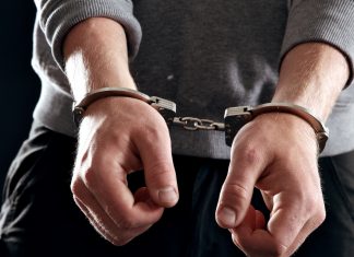 Offender with his hands in handcuffs