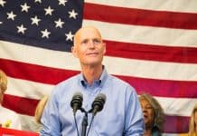 rick scott in front of an american flag