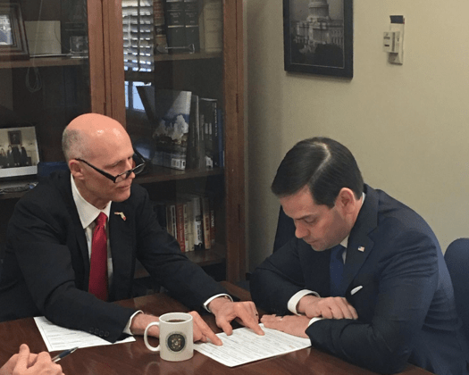 marco rubio and rick scott reviewing document 525x420